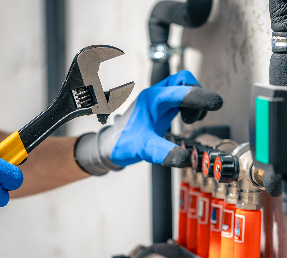Plumber at work, fitting pipes on a bathroom floor with various plumbing tools